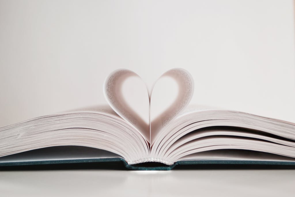 Close-up of open book with pages forming a heart shape, symbolizing love for reading.