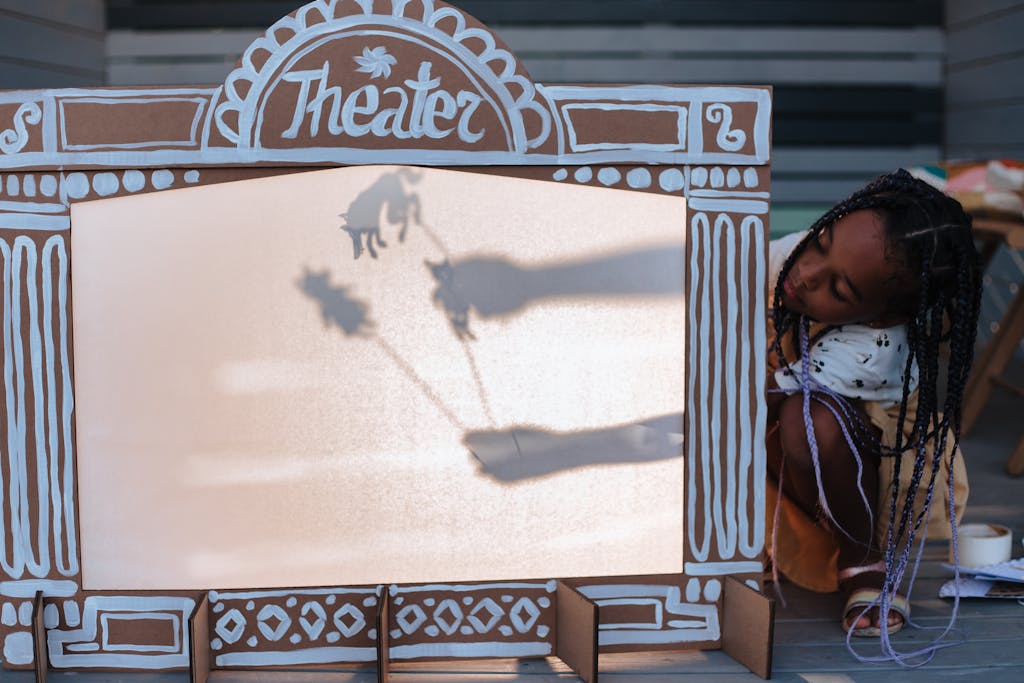Young girl performing a shadow puppet show, showcasing creativity and leisure.